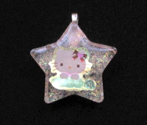 Hello Kitty with a pea pod, it's a bit larger than a quarter. 